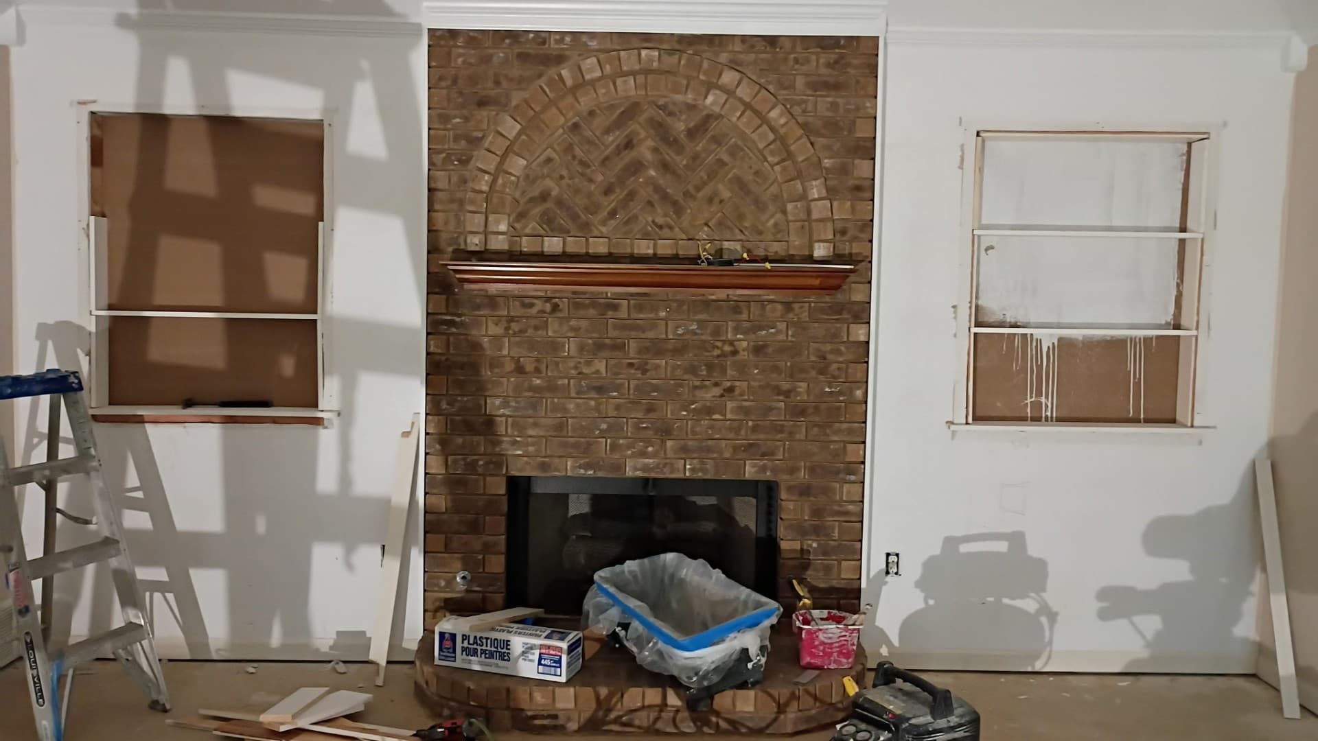 Finished living room with a brick fireplace, trim and drywall work by Drywall & Remodeling ETC. in Memphis, TN